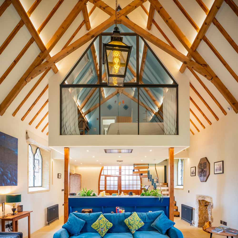 Converted church with living area and elevated pod with a glazed metal screen front