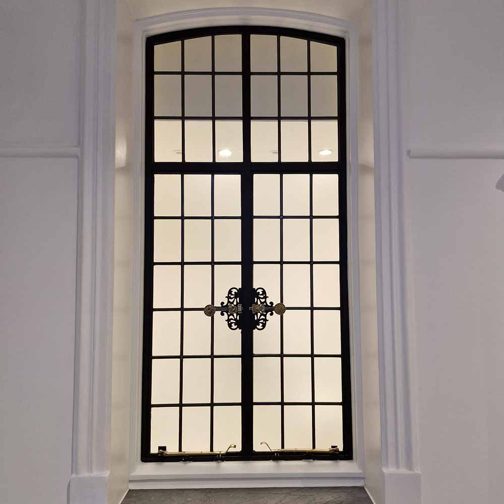 Restored metal window with ornate brass ironmongery