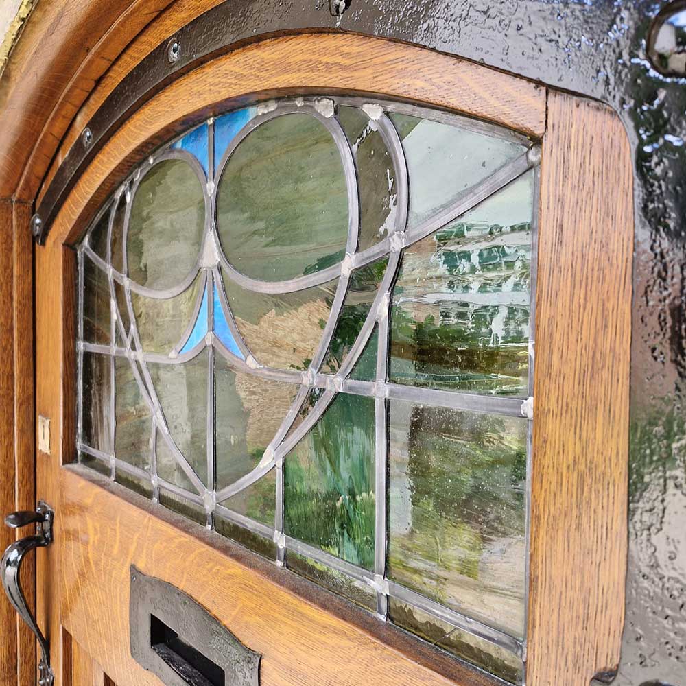 Front door with a restored stained glass window featuring an owl design