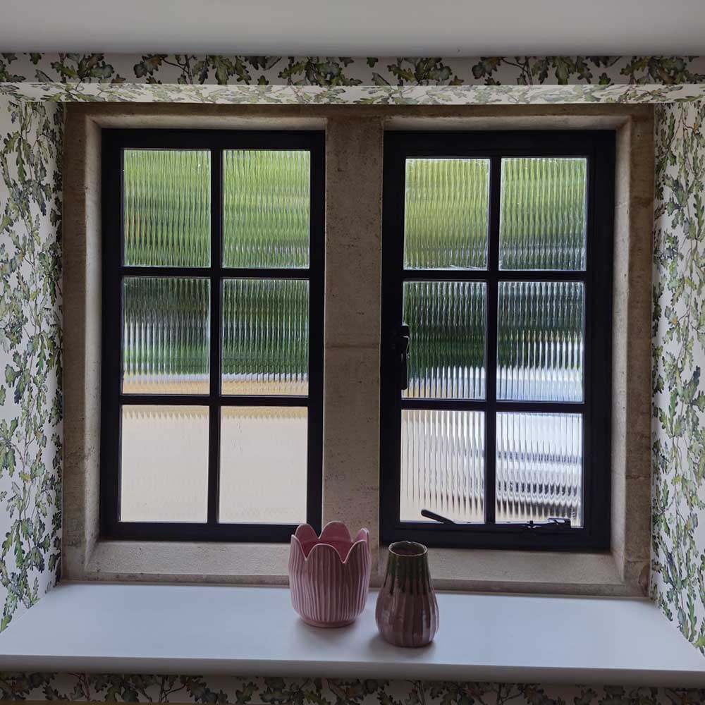 Internal view of replacement subdivided steel windows with fluted glass