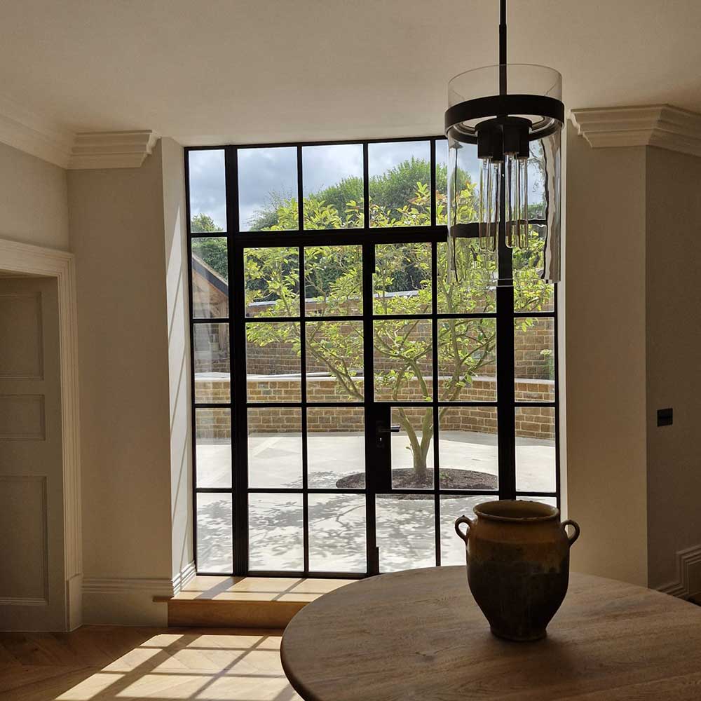 Living area with Bespoke steel doors showing a view of the patio