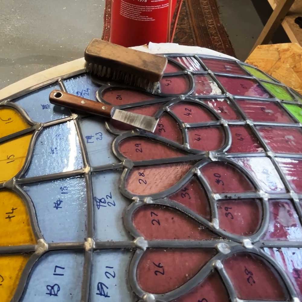 A restored dome panel, showing the vibrant combination of amber, pale blue, mauve and green glass pieces